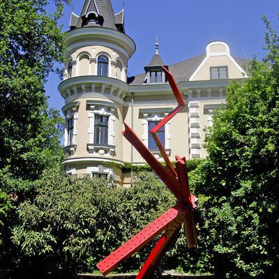 Foto einer roten Skulptur vor der Kebbelvilla