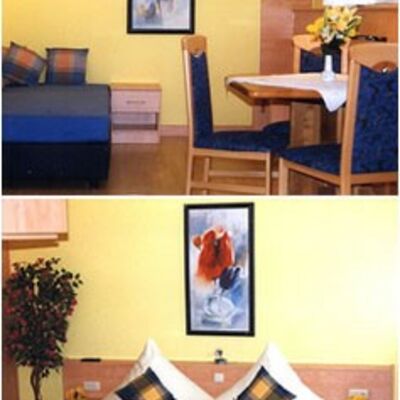 Bild vergrößern: Sitzgruppe mit blauen Sthlen. ber dem Ehebett hngt ein wunderschnes Bild.