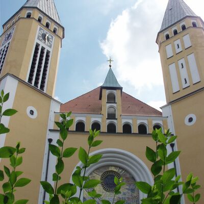 Das Hauptportal der Kreuzbergkirche versteckt sich hinter den Bäumen.