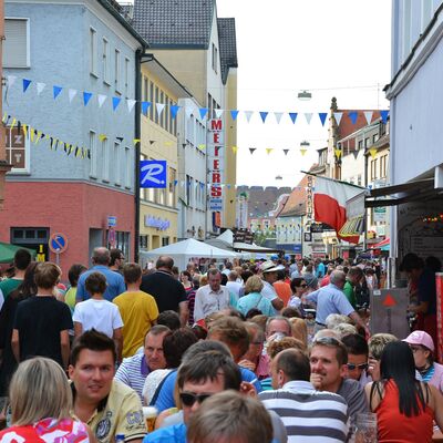 Bild vergrößern: Foto einer Menschenmenge auf der Friedrich-Ebert-Straße beim Bürgerfest 2015. Die Straße ist mit bunten Fahnen geschmückt.