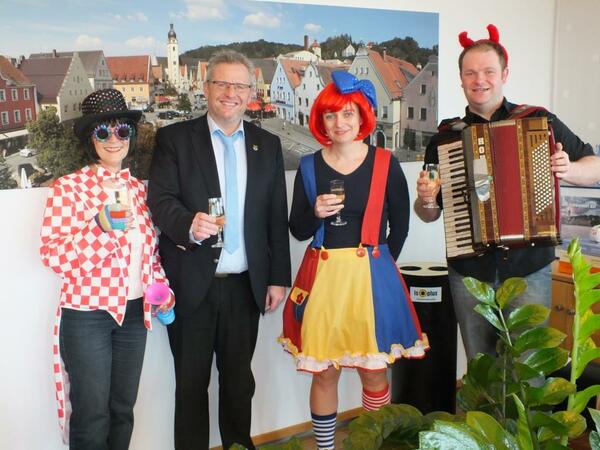 Vier Personen, drei davon maskiert. Einer mit Akkordeon.