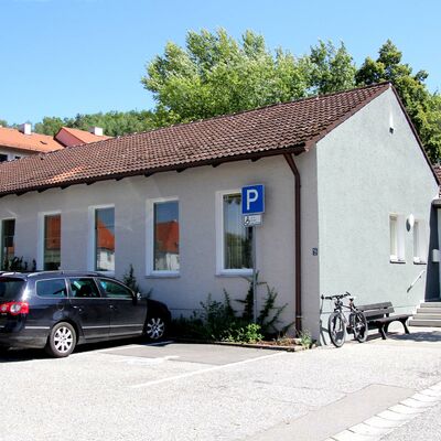 Bild vergrößern: Das graue Gebude der Stadtbibliothek mit groen weien Fenstern.