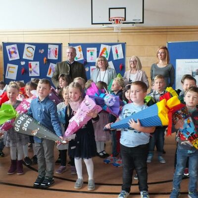 Bild vergrößern: Erstklässler mit Schultüte im Vordergrund. Oberbürgermeister Andreas Feller mit der Schulleitung und Elternsprecher im Hintergrund.