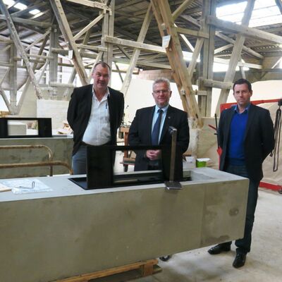 Bild vergrößern: Der Ofen im Kamin ist ein innovatives Produkt der Firma PLEWA. Geschäftsführer Horst Schöffmann erläutert Oberbürgermeister Andreas Feller und Citymanager Roland Kittel die Produktionsschritte. (von links nach rechts)