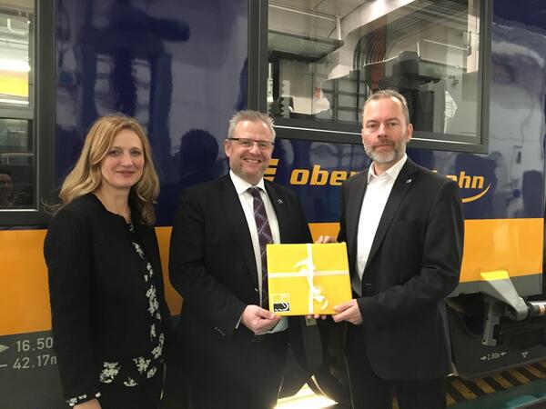 Bild vergrößern: Oberbürgermeister Andreas Feller (Mitte) überreicht zusammen mit Wirtschaftsförderin Maria Schuierer (links) dem neuen Geschäftsführer der Länderbahn, Wolfgang Pollety einen Bildband über die Stadt Schwandorf.