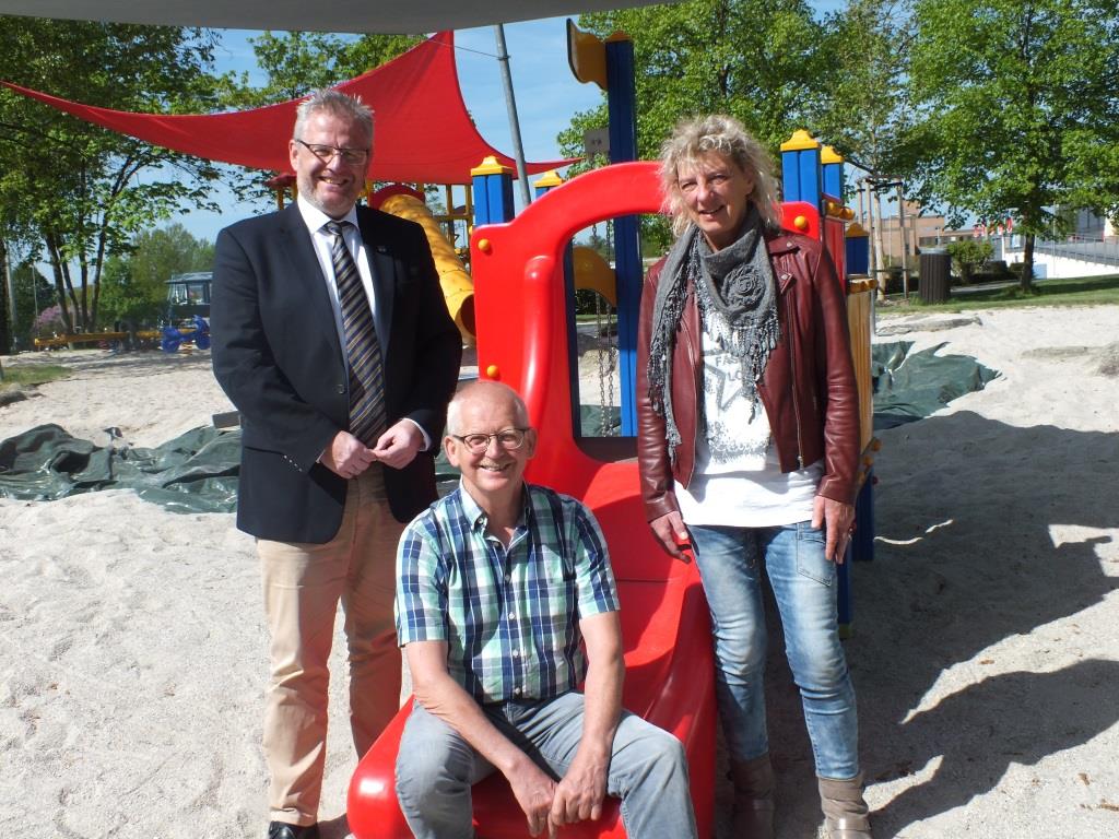 Bild vergrößern: Drei Personen präsentieren die neue Rutschbahn beim Kleinkindbereich des Erlebnisbades.