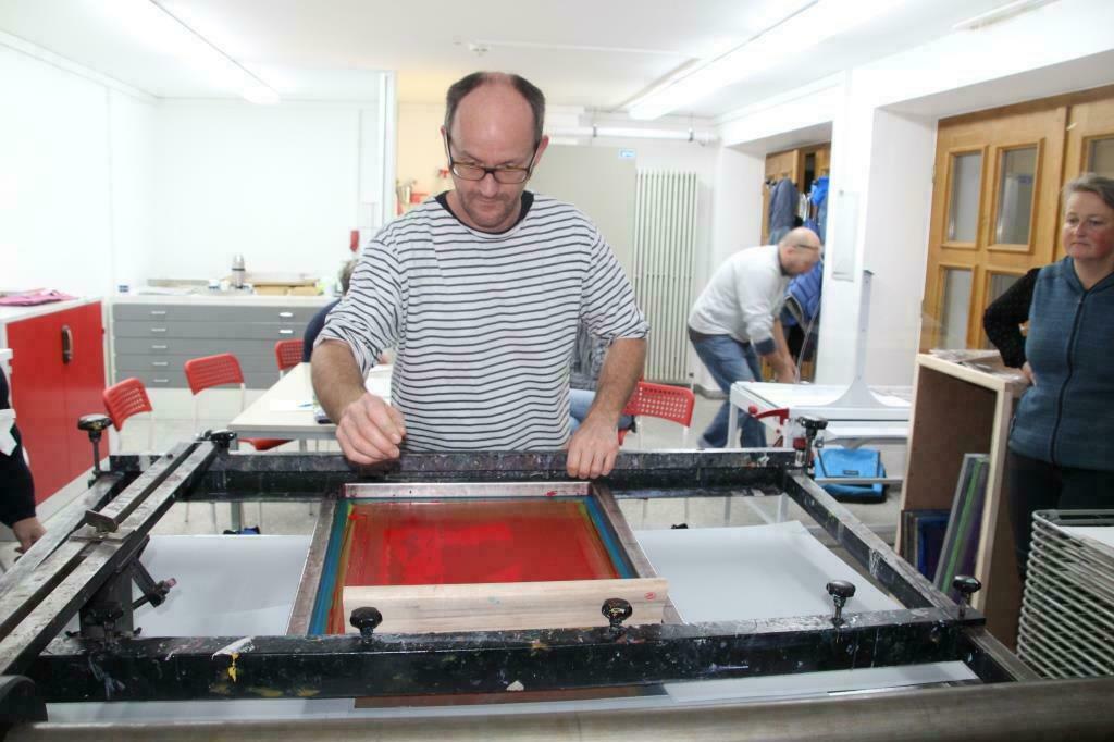 Portrait des Kursleiters an der Siebdruckmaschine