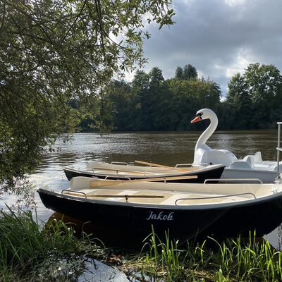 Bild vergrößern: Zwei Ruderboote und ein Tretboot liegen an der Naab bereit.