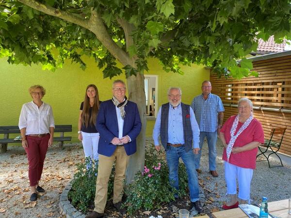 Bild vergrößern: Unter dem Ahornbaum im Lesegarten der Stadtbibliothek verabschiedete OB Andreas Feller (3. von links) den langjährigen Leiter der Schwandorfer Stadtbibliothek, Alfred Wolfsteiner (3. von rechts) in Begleitung seiner Frau Angela Wolfsteiner (rechts außen) in den Ruhestand.
Susanne Lehnfeld; Leiterin Kulturamt, Leonie Flachsmann, neue Bibliotheksleitung und Personalratsvorsitzender Jürgen Liebl wünschten ebenfalls alles Gute für den Ruhestand.