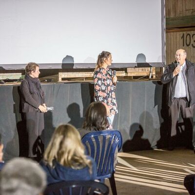 Bild vergrößern: 3 Personen mit einem Mikrofon zugewandt zum Publikum.