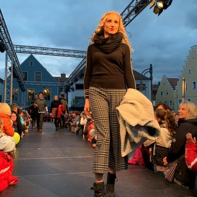 Bild vergrößern: Eine Frau auf einem Laufsteg bei einer Modenschau.