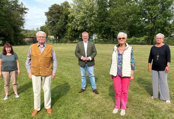 Fnf Personen auf einer Wiese.