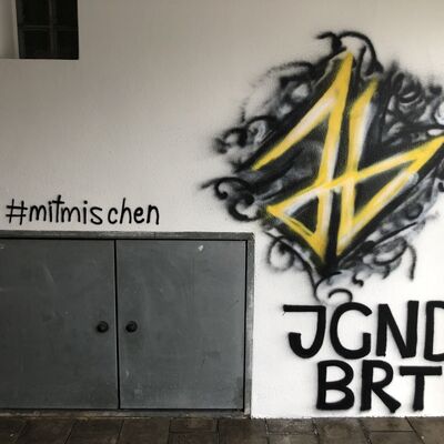 Bild vergrößern: Zu sehen ist ein Graffiti in schwarz und geld vom Jugendbeirat.
Logo und Kurzname "J G N D B R T"