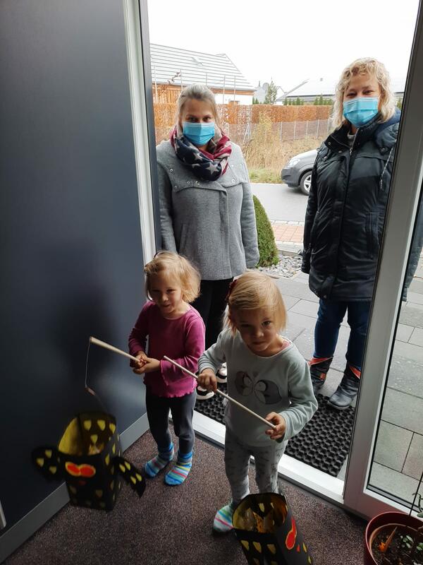Bild vergrößern: Zwei Kleinkinder mit einer Laterne zum Martinstag und zwei Erzieherinnen des staedtischen Kindergartens.