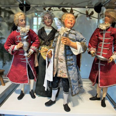 Bild vergrößern: Eine Krippe bestehend aus 4 Figuren von der Familie Pöllmann.
Es sind 3 Männer und 1 Frau, alle tragen lange, mittelalterliche Kleidung.