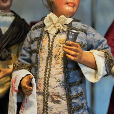 Bild vergrößern: Eine Figur aus der Krippe von der Familie Pöllmann.
Ein Mann mit einem Krug in der Hand und einem langen blauen Gewand.