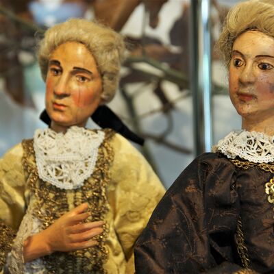 Bild vergrößern: 2 Figuren aus einer freistehenden Krippe. Ein Mann und eine Frau.
Er trägt ein gelbes prachtvolles Gewand und sie ein schönes braunes Kleid. Beide haben die Haare hochgesteckt.
