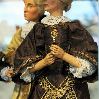 Bild vergrößern: 2 Figuren aus einer freistehenden Krippe. Ein Mann und eine Frau.
Er trägt ein gelbes prachtvolles Gewand und sie ein schönes braunes Kleid. Beide haben die Haare hochgesteckt.