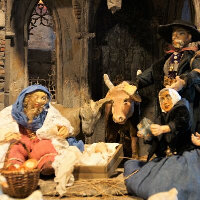 Bild vergrößern: Die Straubinger Krippe: Verbindung von Gäu und Wald zeigt 10 verschiedene Figuren, die sich auf dem Vorplatz des Burggrabens und unter einem halben Haus tummeln. Die Figuren auf dem Vorplatz tragen prächtige Kleidung. Die Figuren in dem halben Haus sehen dahingegen eher ärmlich aus.