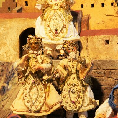 Bild vergrößern: Die Straubinger Krippe: Verbindung von Gäu und Wald zeigt 10 verschiedene Figuren, die sich auf dem Vorplatz des Burggrabens und unter einem halben Haus tummeln. Die Figuren auf dem Vorplatz tragen prächtige Kleidung. Die Figuren in dem halben Haus sehen dahingegen eher ärmlich aus.