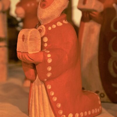 Bild vergrößern: Zu sehen ist einer der Heiligen Drei Könige, welcher kniet und eine kleine Truhe in den Händen hält. Aus Keramik gefertigte Truhe.