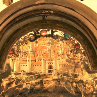 Bild vergrößern: Die Burg aus der "Rokoko Kastenkrippe" zeigt weiße Burgmauern mit roten Dächern. Die Burg erstreckt sich sowohl nach hinten als auch nach oben.
