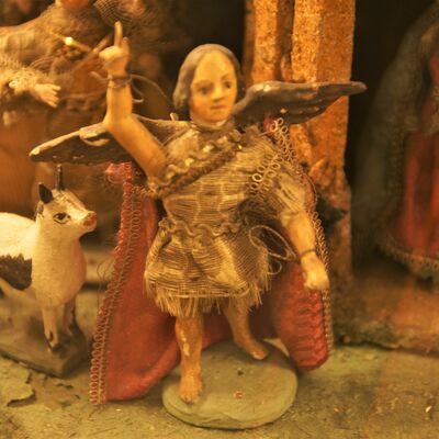 Bild vergrößern: Eine Figur aus der "Rokoko Kastenkrippe". Es ist ein Engel der den Finger hebt, als möchte er etwas ankündigen.