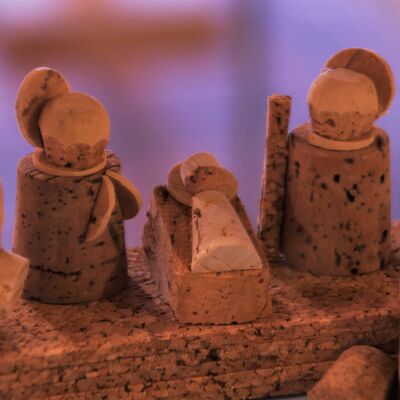 Bild vergrößern: Aus dem Material Kork gefertigte Figuren. Zwei Figuren stehen neben einer Krippe, in der ein Baby liegt. Ebenso aus Kork gefertigt. Die Figuren haben einen Heiligenschein aus Kork hinter dem Kopf.
