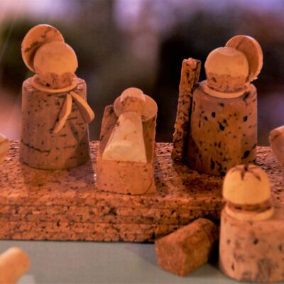 Bild vergrößern: Aus dem Material Kork gefertigte Figuren. Zwei Figuren stehen neben einer Krippe, in der ein Baby liegt. Ebenso aus Kork gefertigt. Die Figuren haben einen Heiligenschein aus Kork hinter dem Kopf. Im Vordergund ist eine weitere Korkfigur mit einer Krone dargestellt.