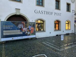Bild vergrößern: Die Hausfassade der Gaststätte "Zur Post". Die Fenster sind beleuchtet.