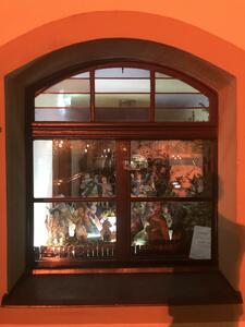 Bild vergrößern: Ein Fenster der Gaststätte "Zur Post" in dieser eine Krippe ausgestellt ist. Die ca. 15 Figuren sind aus Pappe und relativ groß. Die Kleidung der Figuren ist bunt gemischt.