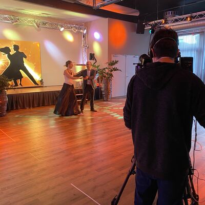 Foto: Anna und Stefan Theuerl tanzen vor einer Filmkamera auf der leeren Tanzfläche in ihrer Schule.