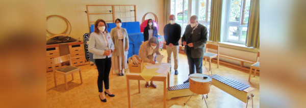 6 Personen stehen in einem Klassenzimmer