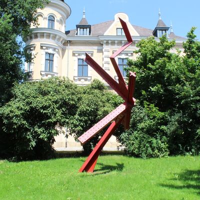 Bild vergrößern: Im Park des Oberpfälzer Künstlerhauses bedindet sich unter anderem eine rote Stahlskulptur mit dem Namen "Der Tänzer".
