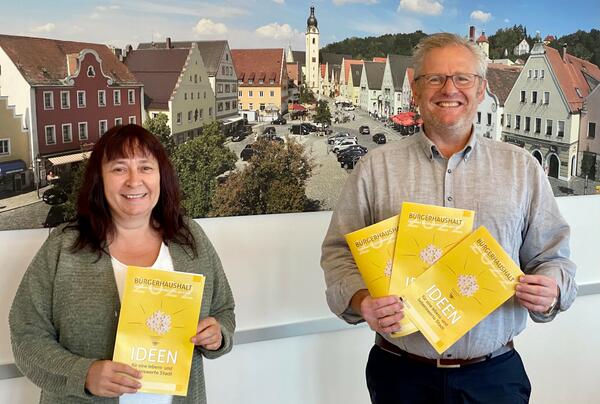 Bild vergrößern: Zwei Personen präsentieren die Flyer für den Bürgerhaushalt 2022.