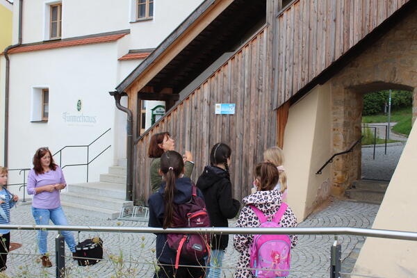 Die Gästeführerin erklärt den Kindern die Holztreppe am Blasturm.