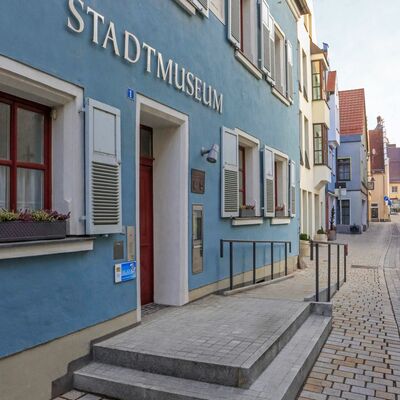 Bild vergrößern: Seitliche Aufnahme von der blauen Fassade des Stadtmuseums. ber der hlzernen Eingangstr hngt in silbernen Grobuchstaben der Schriftzug "Stadtmuseum"