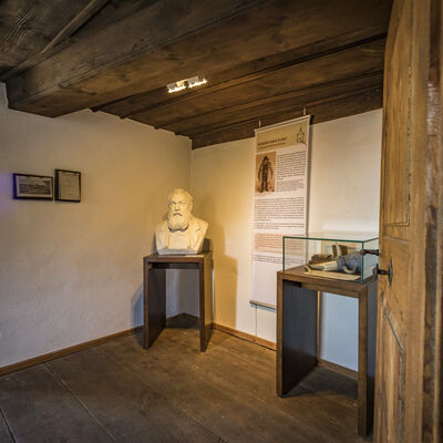 Bild vergrößern: Im kleinen Zimmer steht in der Ecke auf einem kleinen Holztisch die weie Bste von Konrad Max Kunz. Der Boden ist aus Holzdielen, genauso die Decke.