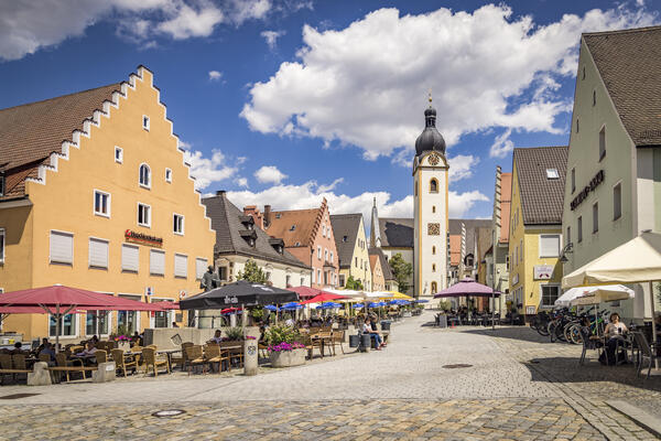 Bild vergrößern: Sitzgelegenheiten, die zum Verweilen einladen, bieten einen schönen Blick auf die Pfarrkirche St. Jakob. Bunte Altstadthäuser mit schönen Giebeln säumen den Platz.