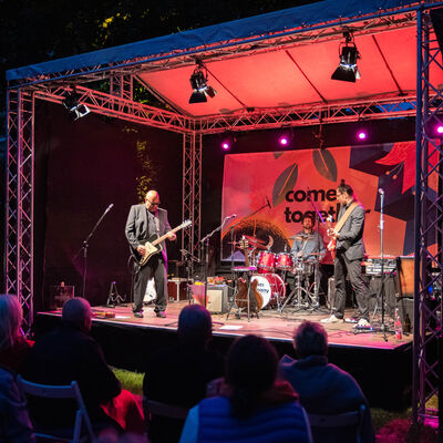 Band auf der rot beleuchteten Bühne.