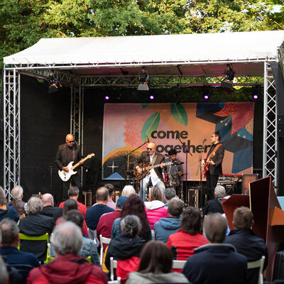 Band auf der Bühne. Im Vordergrund das Publikum.