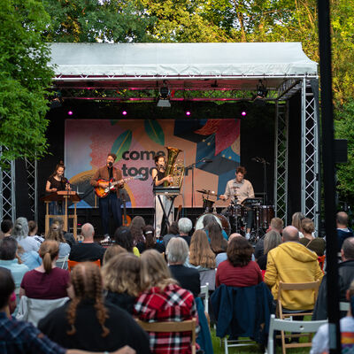 Band auf der Bühne und im Vordergrund das Publikum.