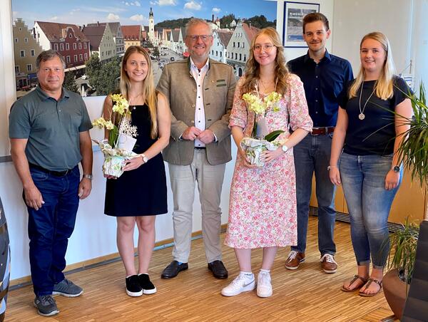 Das Bild zeigt drei Frauen und drei Mnner. Zwei Frauen haben einen Blumenstock in der Hand.