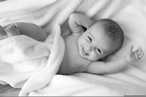 Bild vergrößern: Das Bild zeigt ein Baby das lchelt.