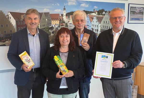 Bild vergrößern: Das Bild zeigt ein Frau und drei Männer. Sie präsentieren ein Urkunde für fairen Handel.