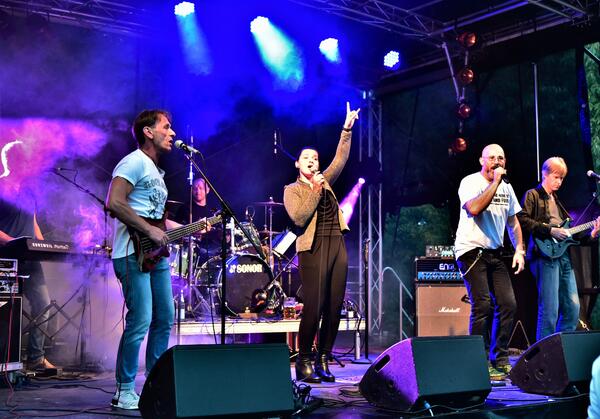 Bandfoto auf der Bhne.
Zwei Mnner une eine Frau