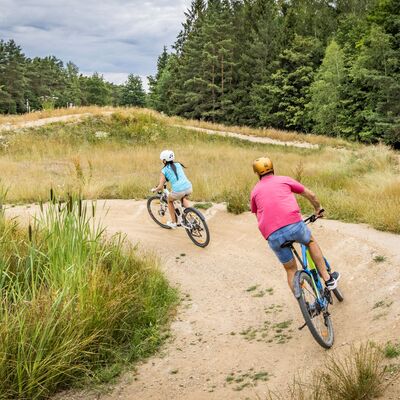 Bild vergrößern: Radfahrer fahren durch den Dirtbike Park.