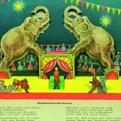 Bild vergrößern: Ein Zirkus von innen, mit zwei Elefanten, die ein Kunststück machen
