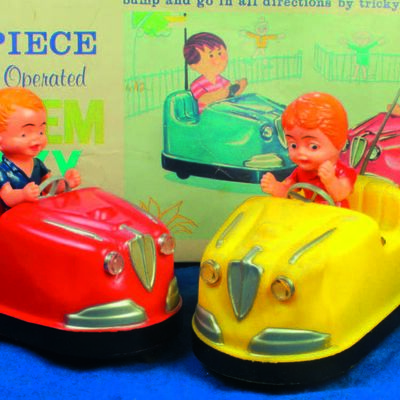 Bild vergrößern: Altes Blechspielzeug. Zwei Autos in denen jeweils ein Kind drin sitzt.