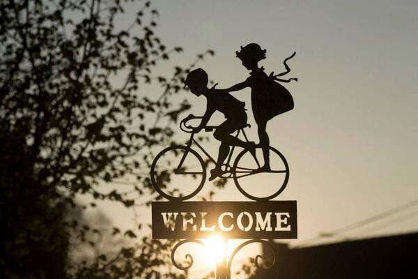 Ein Belchschuld mit zwei Kindern auf einem Fahrrad, darunter steht "Welcome"